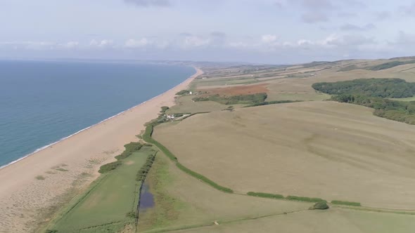 Aerial tracking from right to left above the stunning Chesil beach which stretches west along the co