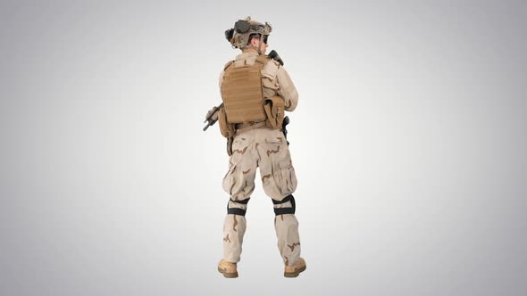 Fully Equipped Solder Holding Assault Rifle and Standing Looking To the Sides on Gradient Background