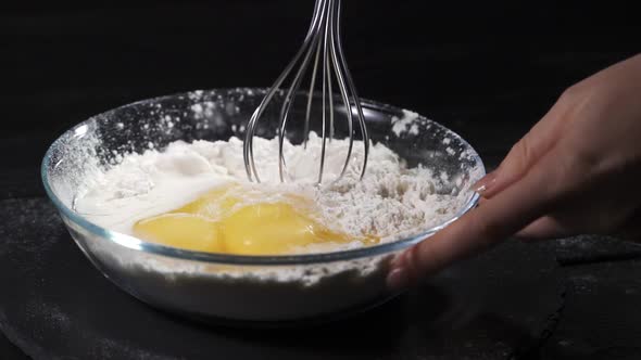 Mom with Daughter in the Kitchen Knead the Dough in a Plate. Mother Teaches Her Child To Cook