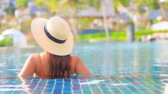 Young asian woman enjoy around outdoor swimming pool for leisure