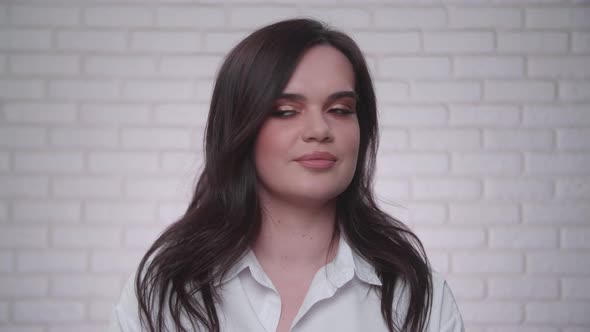 Portrait of a Woman Smiling After Applying Professional Makeup in the Studio