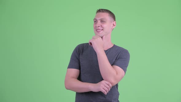 Portrait of Happy Young Man Thinking and Looking Up