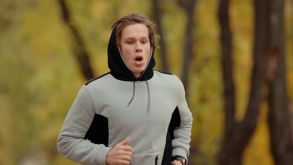 Man Jogging in a Park and Measuring Pulse in the Watch