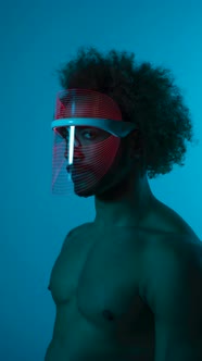 Timelapse shot of man wearing light therapy mask against blue wall