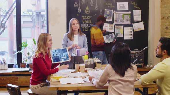 Female Designers Using Tablet and Showing Interior Project to Clients