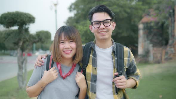 Asian couple feeling happy smiling to camera holiday trip at Ayutthaya, Thailand, backpacker enjoy