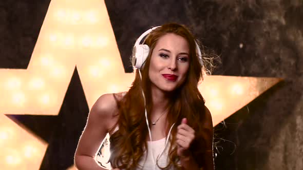 Young Woman in Headphones Singing a Song with a Microphone. Slow Motion, Silhouette, Close Up