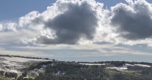 Time Lapse of Cloudscape Behind of the Mountains Top. Snow, Rocks, Cliffs and Deep Blue Sky. High