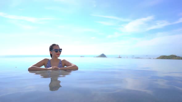 Young asian woman enjoy around outdoor swimming pool for leisure