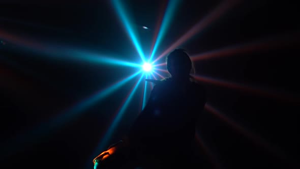 Silhouette of a Talented Young Girl Hip Hop Dancer. Hip Hop Street Dance on a Stage in Dark Studio