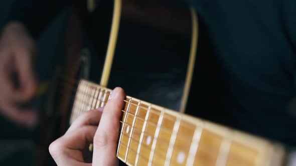 Person Strikes Barre Chords Playing Acoustic Guitar Closeup