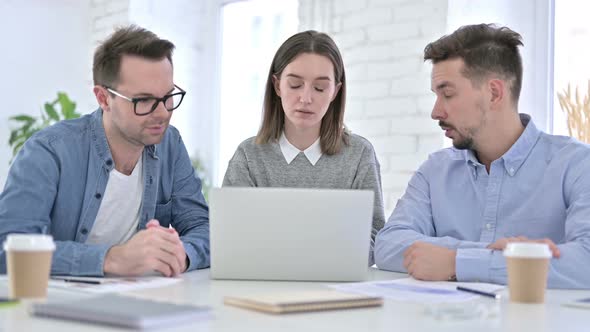 Three Creative Professionals Working on Laptop Together