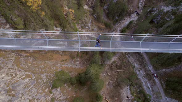 Girl Crossing a Footbridge Spanning a Ravine