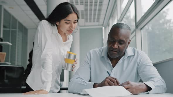 Arab Businesswoman Team Leader Explain Marketing Documentation Report to African American Colleague