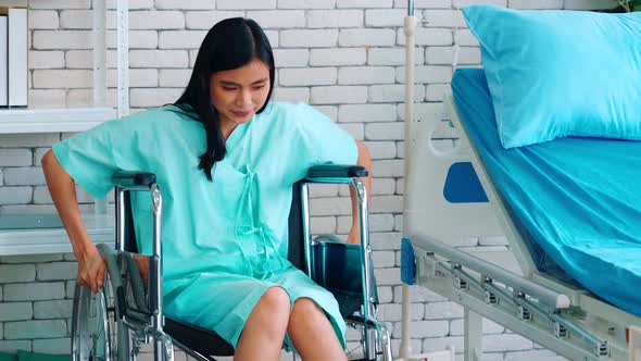 Young Happy Asian Woman on Wheelchair in a Hospital Ward