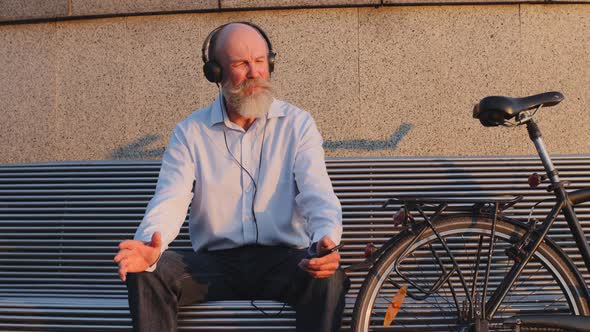 Funny Grayhaired Mustachioed Bearded Cyclist Sits on City Bench Resting After Trip