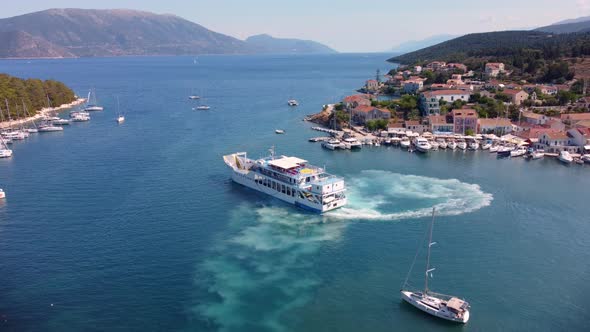 Drone flying over the beautiful marina and town of Fiskardo in Greece. There are a lot of boats and