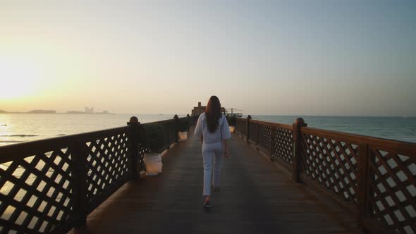 Woman Walking on Wooden Pier and Looking at Burj Al Arab Hotel in Dubai