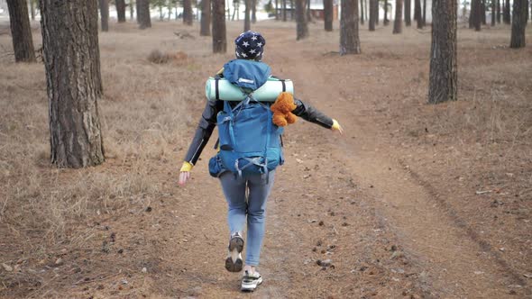 Happy Tourist with Backpack on Forest Pine Trees