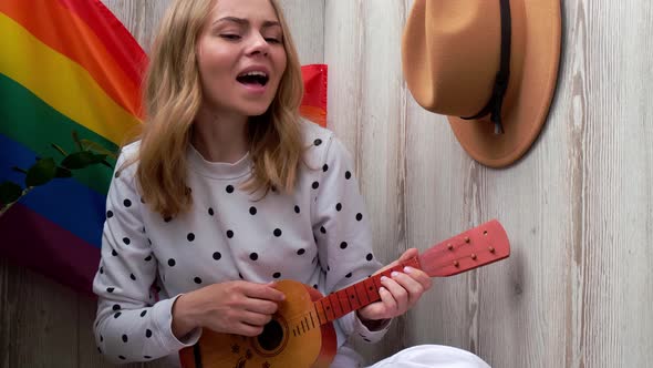 Young Millennial Hippie Woman Sitting on Balcony Play Guitar