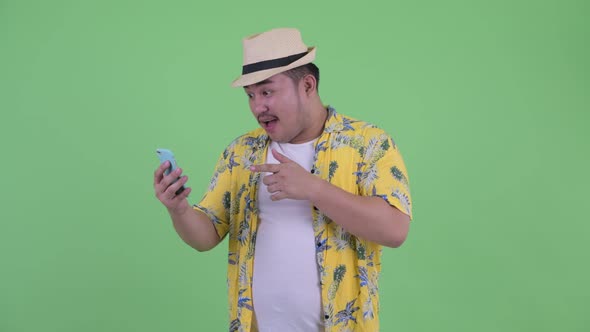 Happy Young Overweight Asian Tourist Man Video Calling and Showing Phone