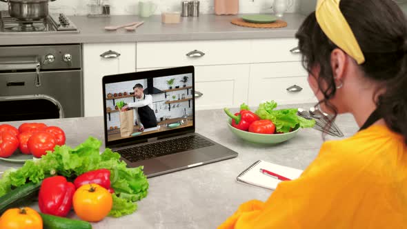 Woman Housewife in Kitchen Study Online Video Call Laptop Greets Listen Teacher