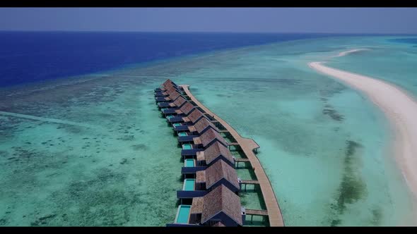 Aerial flying over panorama of marine bay beach wildlife by transparent lagoon with white sand backg