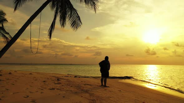 Pretty happy lady relaxing by the sea at the beach on clean white sand and blue background 4K