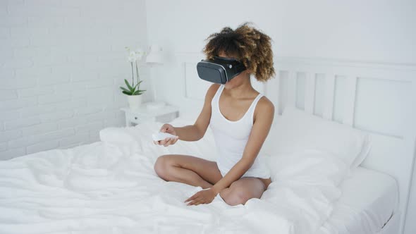 Content Woman in VR Glasses on Bed