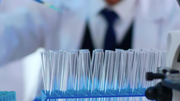 Close Up of Chemist Filling Test Tube with Liquid Using Pipette