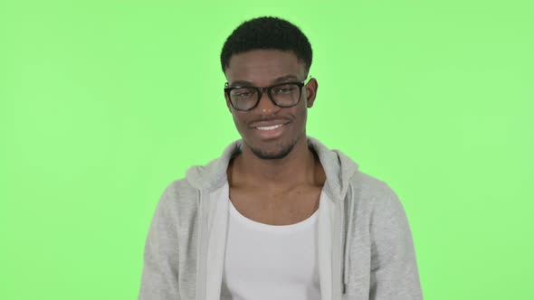 African Man Shaking Head As Yes Sign on Green Background