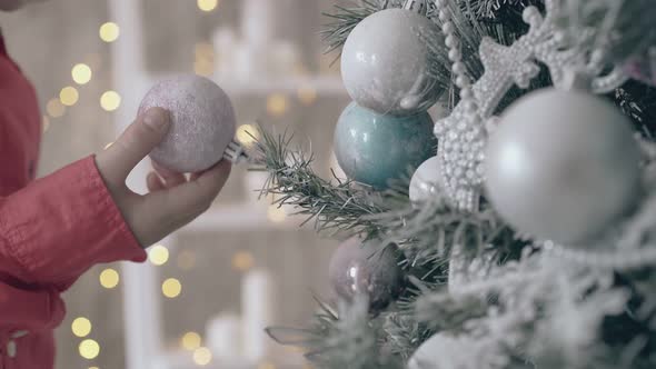 Curious Child Picks Up Pink Decoration From Christmas Tree