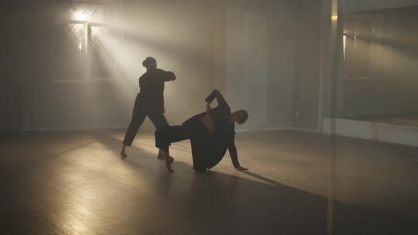 Wide Shot Reflection in Mirror of Two Graceful Slim Ballerinas Rehearsing Modern Performance in