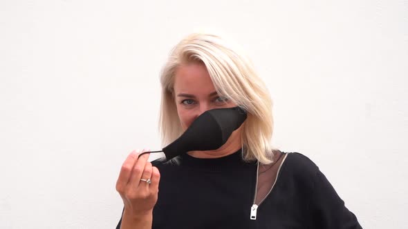 Blond smiling happy girl putting on mask
