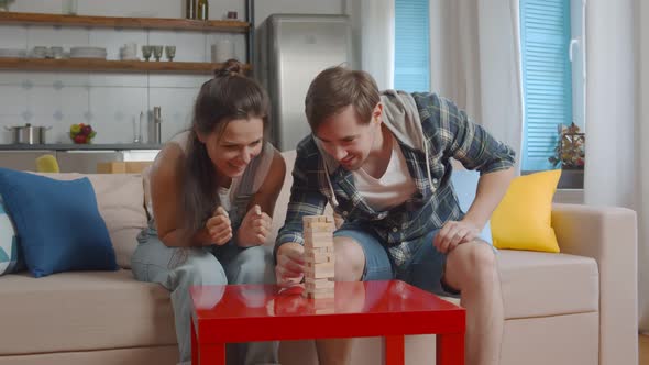 Young Happy Couple Playing Table Game Together at Home