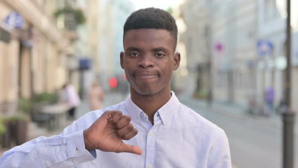 Portrait of African Man Showing Thumbs Down Gesture Outdoor