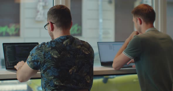 Two IT Programmers Are Working on Computer in a Modern Office Room. Web Developers Working at the