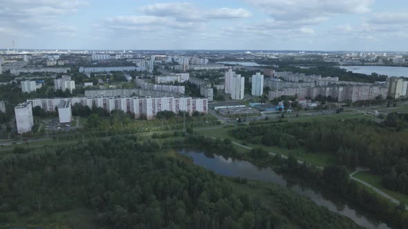 City landscape. Nearby there is a park area. Blue sky with white clouds. Aerial photography.