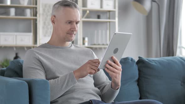 Gray Hair Man Celebrating Success While Using Tablet