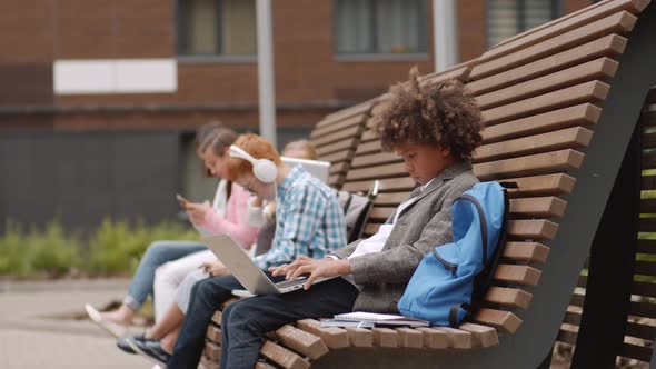 Diverse Pupils Using Gadgets during Break