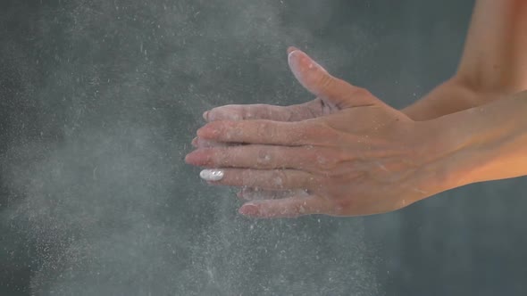 Muscular Woman Clapping Hands with Talc Powder in a Gym