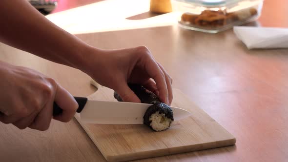 Cutting down a sushi roll in the kitchen.