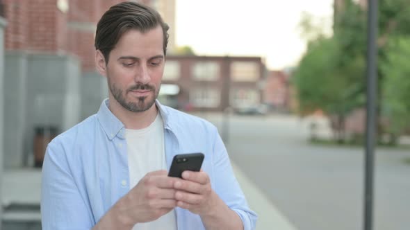 Man Using Smartphone While Standing Outdoor