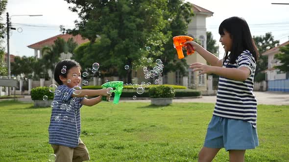 Cute Asian Children Shooting Bubbles From Bubble Gun In The Park Slow Motion