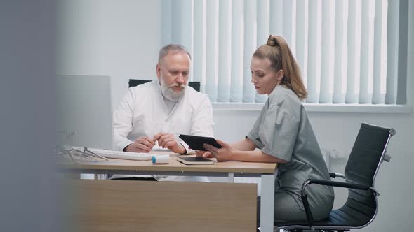 Medical Specialists Discuss the Methods of Treating Patients an Adult Male Doctor and a Female Nurse