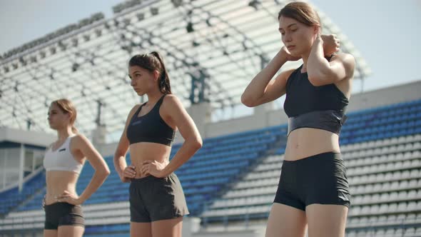 Side View of a Group Female Athlete Starting Her Sprint on a Running Track. Runner Taking Off From