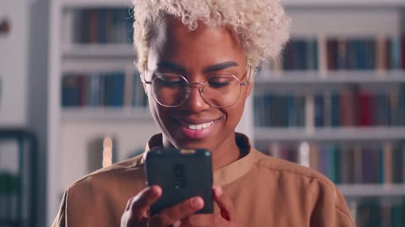 Smiling Young African American Woman Enjoying Using Mobile Software Applications