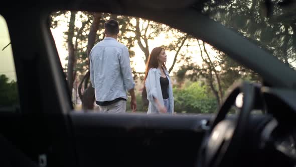 Shooting From Car of Caucasian Couple Gesturing Hitchhiking Standing in Suburb Forest