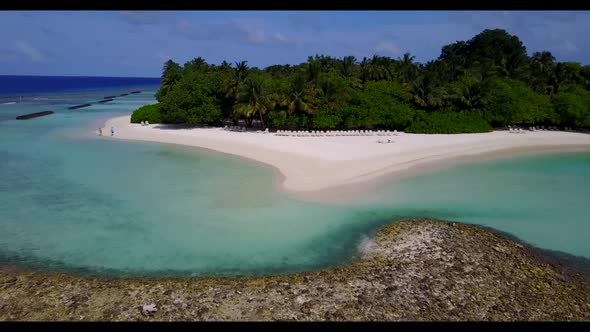 Aerial drone shot scenery of tropical tourist beach trip by turquoise ocean with white sand backgrou