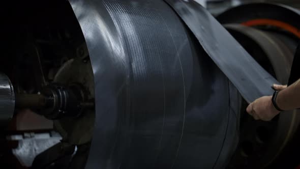 Tyre Factory Worker Hands Setting New Rubber Tape on Industrial Workshop Machine